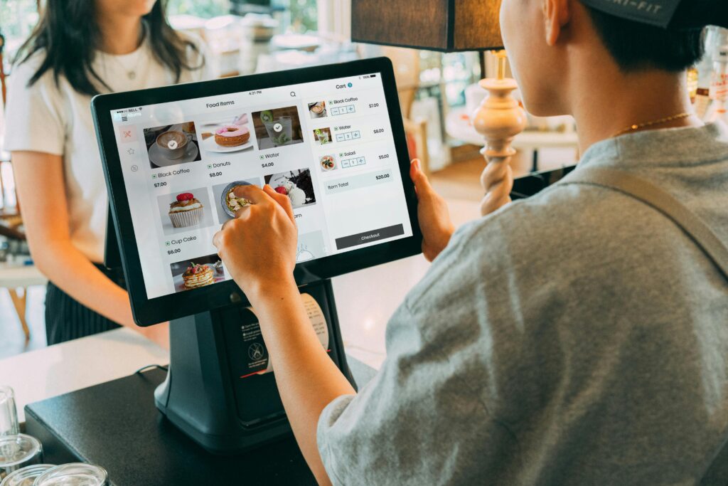 Waiter using smart card machine EPOS system to take customer order in Irish restaurant