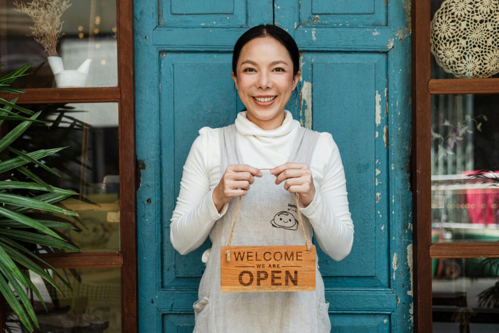 Irish business owner displaying contactless payment acceptance sign outside retail shop entrance