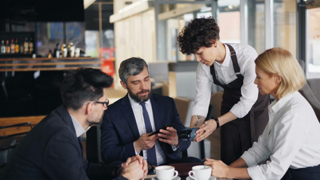 Business people making contactless payment in a restaurant using a modern card machine