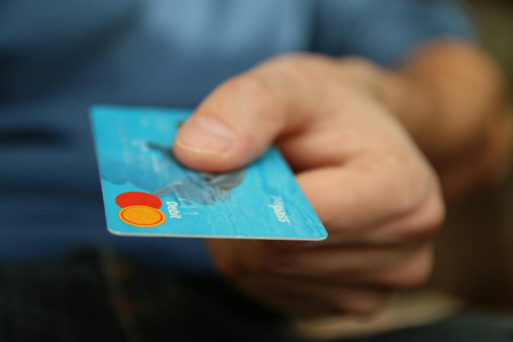 Multi-currency payment comparison showing hand presenting international credit card for cross-border transaction